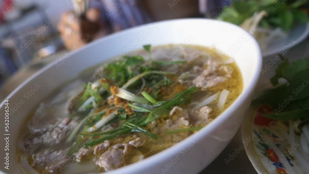 Woman in bikini eating traditional vietnamese pho beef noodle soup in local restaurant. Woman in bikini eating traditional vietnamese pho beef noodle soup in local restaurant.