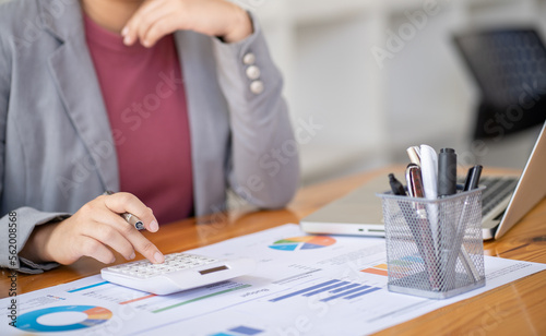 Businesswoman Accountant analyzing investment charts Invoice and pressing calculator buttons over documents. Accounting Bookkeeper Clerk Bank Advisor And Auditor Concept