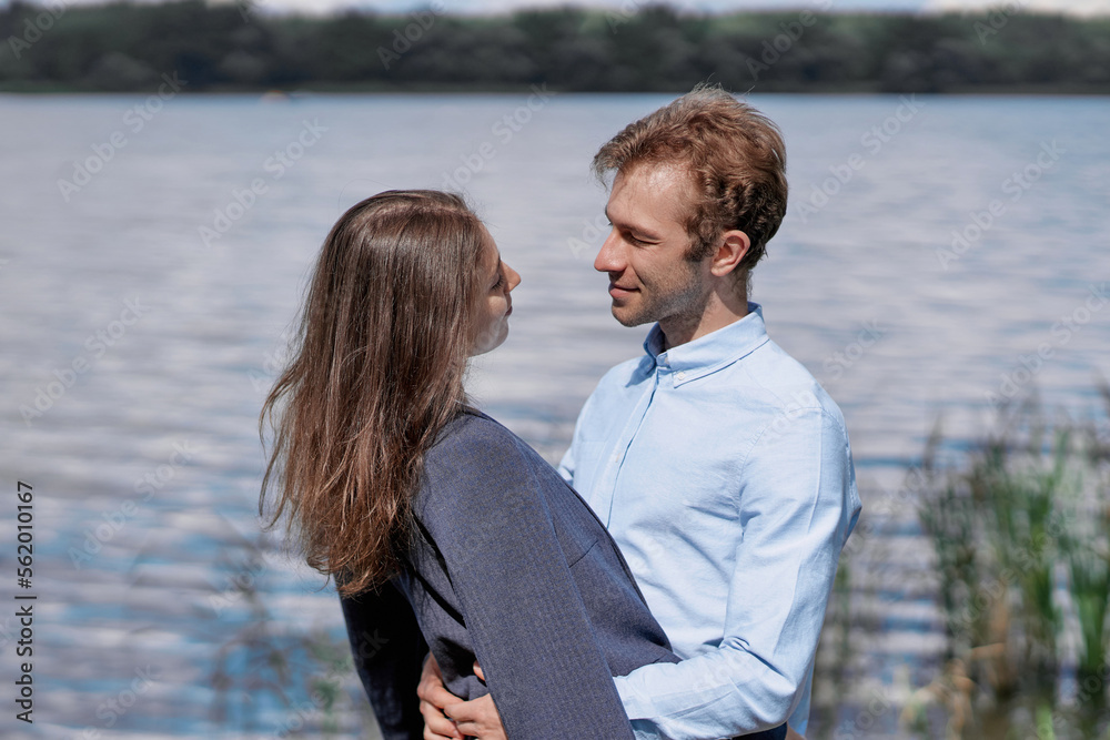 couple in love standing together on the shore of the lake . couple in love standing together on the shore of the lake .