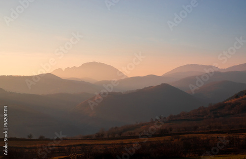 Landscape with the ridges of the Apuseni mountains - Romania in a foggy evening