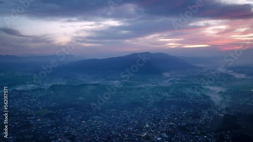 Wide aerial footage in the blue light of the sunrise of the city of San Juan Ostuncalco and the mountains behind it in the haze. photo