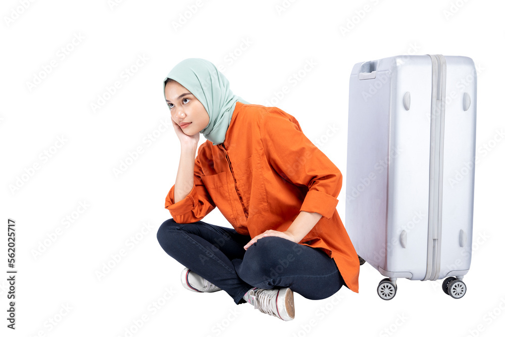 Asian Muslim woman in a headscarf sitting with a suitcase Asian Muslim woman in a headscarf sitting with a suitcase