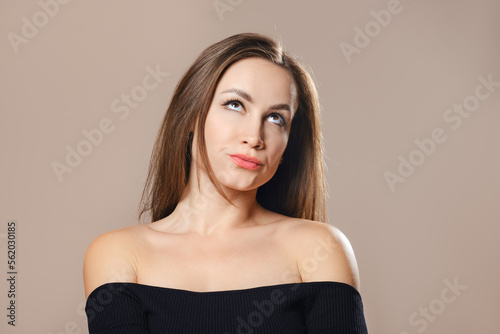 Studio portrait of sceptical woman pursing her lips © boomeart