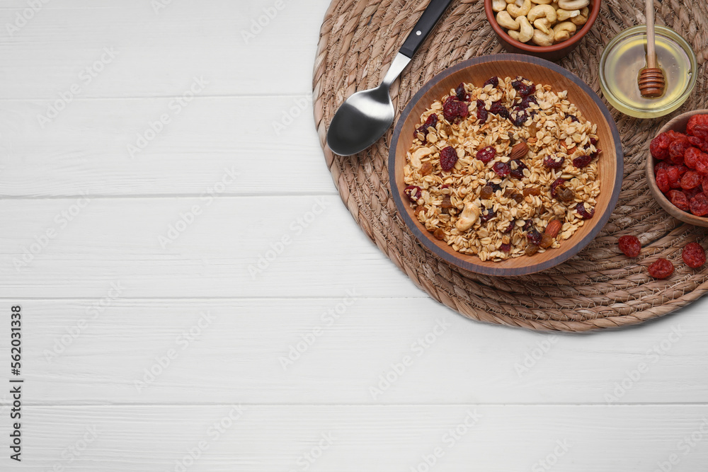 Tasty granola with nuts and dry fruits on white wooden table, flat lay. Space for text