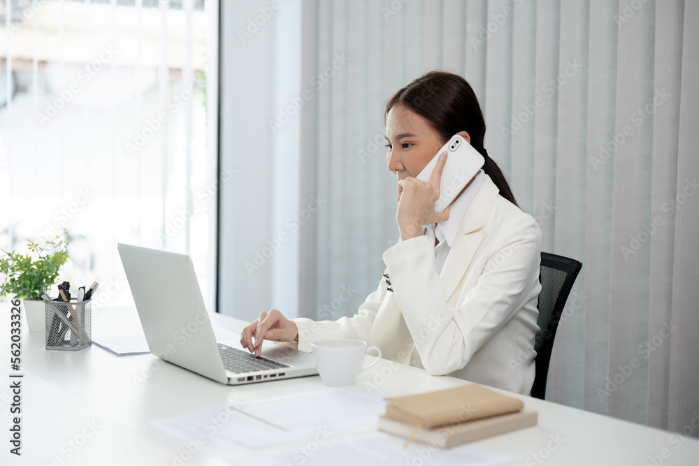 Asian businesswoman working on laptop and mobile phone Start up small business owner. business successful technology concept Asian businesswoman working on laptop and mobile phone Start up small business owner. business successful technology concept