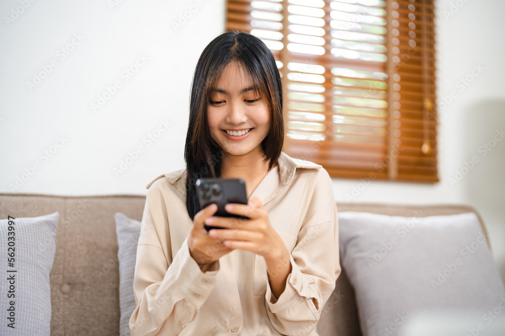 Asian girl using cell phone for checking social media at home holding smartphone in morning. Asian girl using cell phone for checking social media at home holding smartphone in morning.