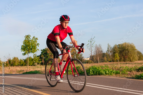 Cycling Ideas. One Emotional Male Cyclist Riding Road Bike Uphill Equipped with Summer Bike Outfit Posing Outdoor During Training.