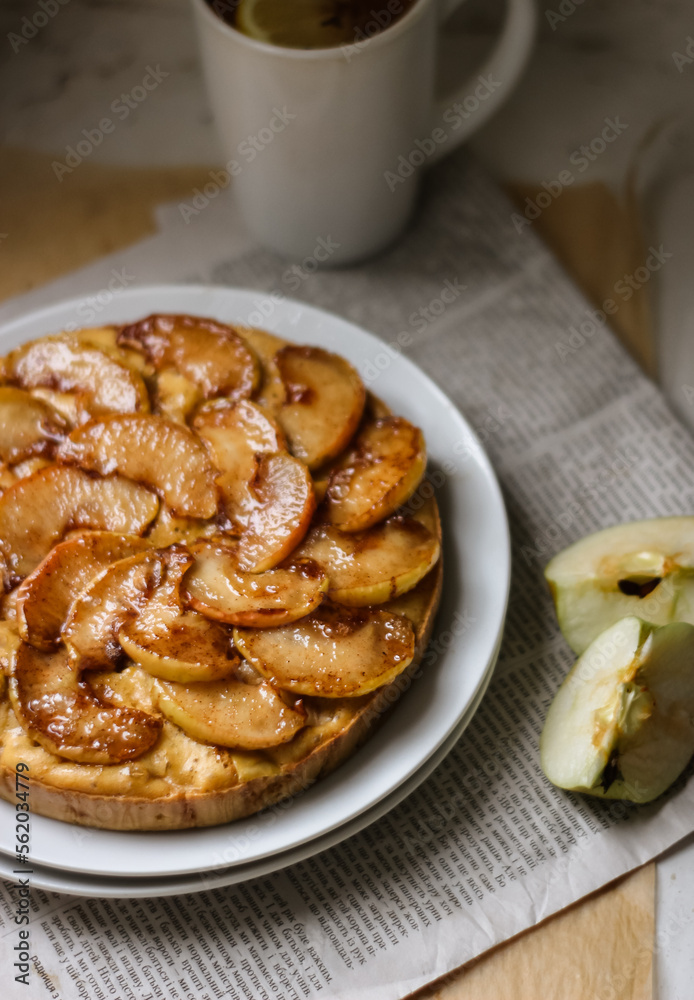Fresh apple pie on the white plate, the pie is decorated with caramelized apple slices, an appetizing pie on a newspaper background, sweet homemade pastry with apples
Fresh apple pie on the white plate, the pie is decorated with caramelized apple slices, an appetizing pie on a newspaper background, sweet homemade pastry with apples
