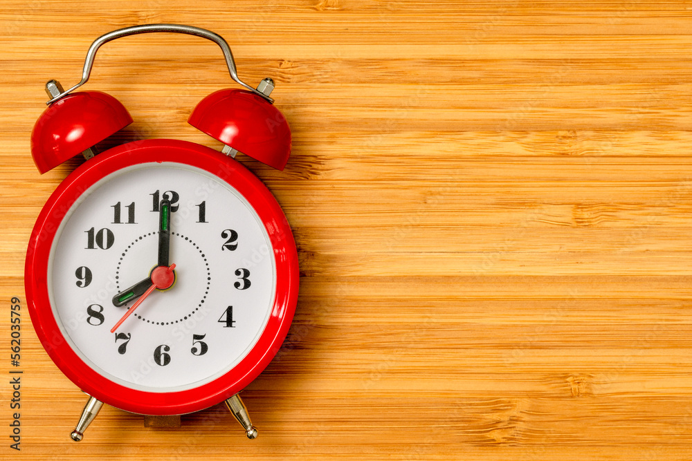 Red alarm clock showing 8 o'clock Red alarm clock showing 8 o'clock