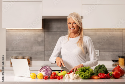 Beautiful woman preparing healthy and delicious food in a modern kitchen 