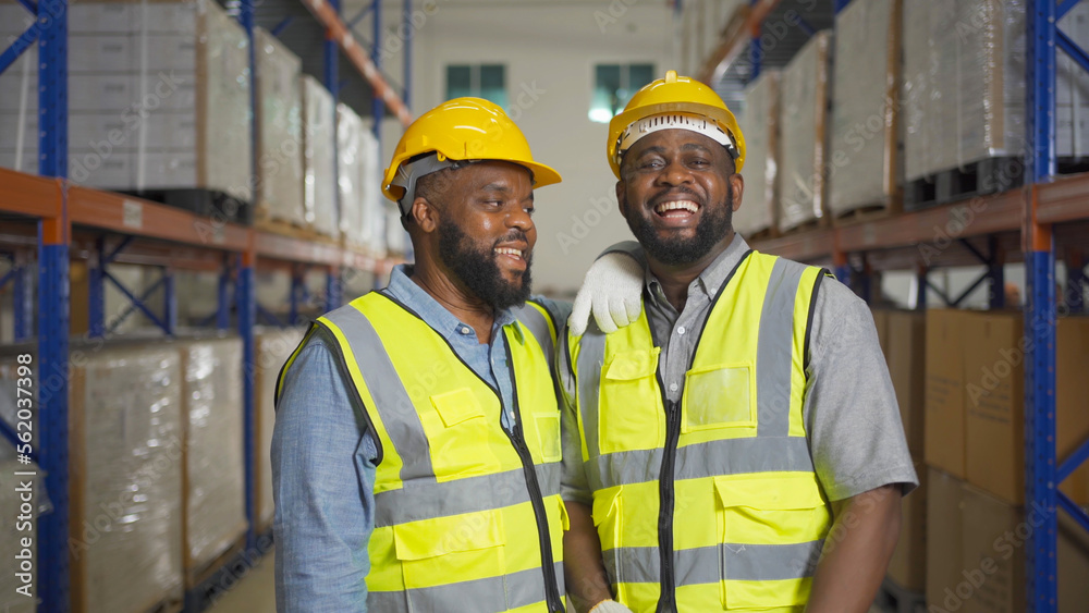 Teamwork of black workers working in large warehouse store industry.Rack of stock storage. Interior of cargo in ecommerce and logistic concept. Depot. People lifestyle. Shipment service for container