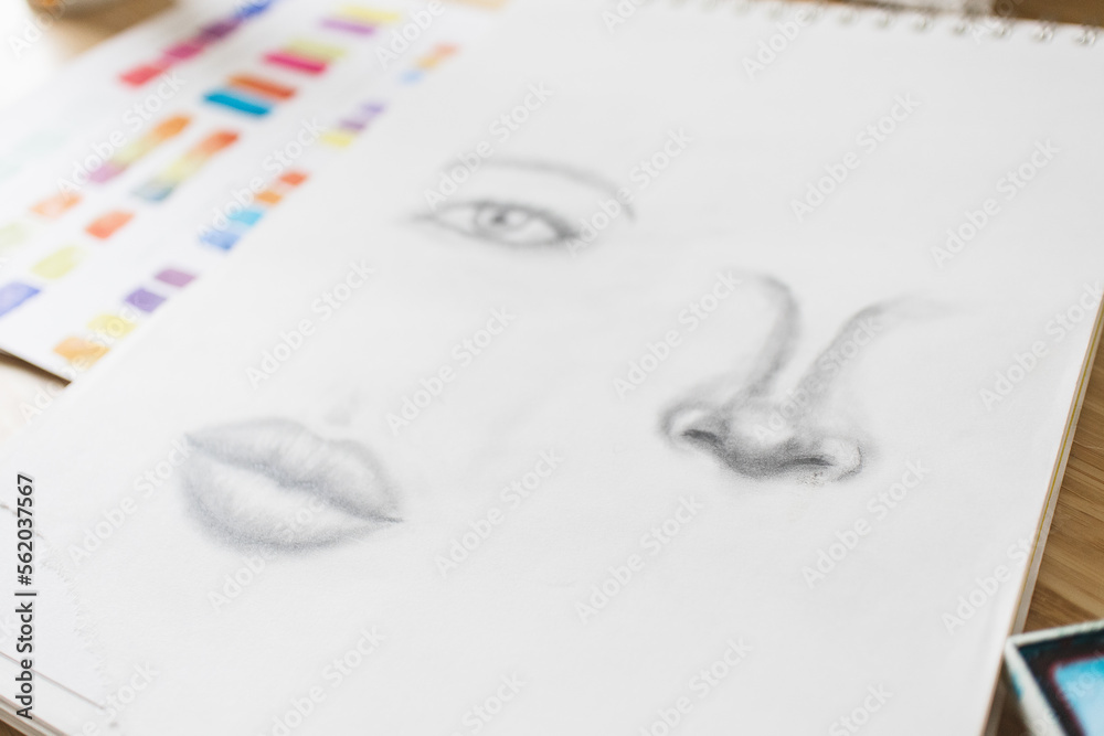 Fototapeta premium Sketch on Art Desk with Paintings and Brush Colorful Creative Creativity