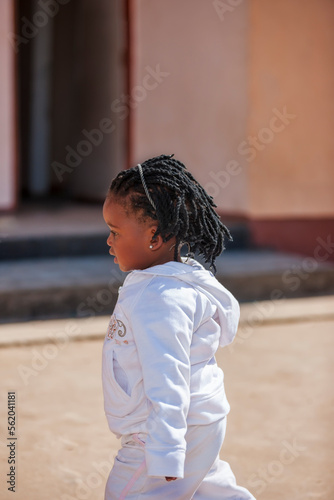 cute toddler girl with braids portrait, in her village in Botswana