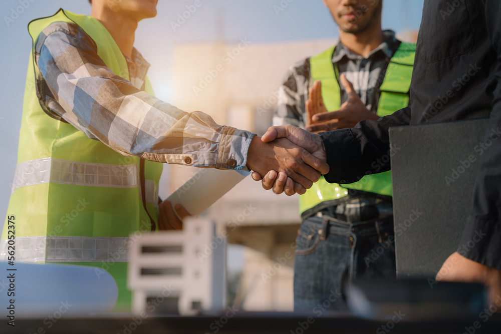 construction worker and contractor. Client shaking hands with team builder in renovation site in the morning.