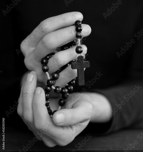 praying to God with hands together with cross on black background with people stock photo