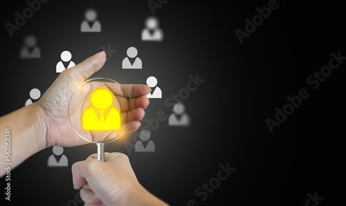 A hand with a magnifying glass and the other holding a found potential personnel icon, among many others. HRM or Human Resource Management. 