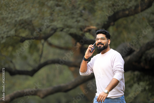 Young indian man talking on smartphone.