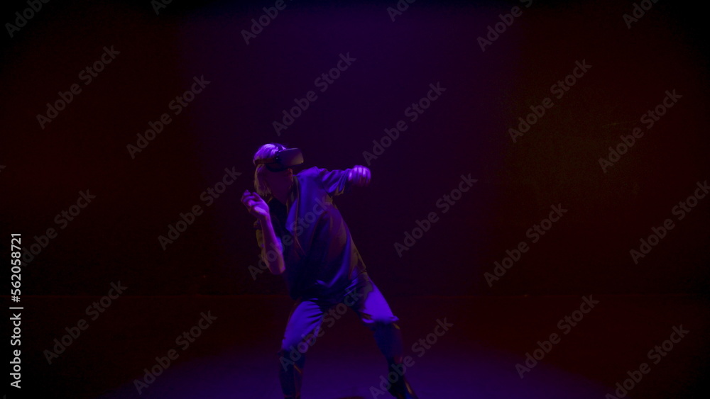 Neon lights gamer dancing in virtual reality headset. Energetic man enjoying Neon lights gamer dancing in virtual reality headset. Energetic man enjoying