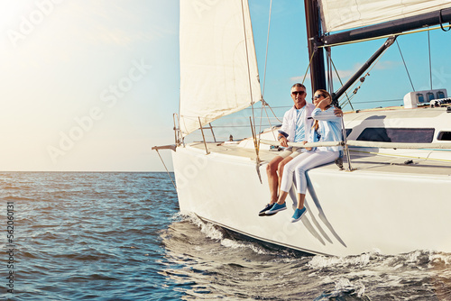 Yacht, travel or love and a mature couple sitting on a boat out at sea with blue sky mockup and flare. Ocean, summer and luxury with a man and woman on a ship to relax on the water in nature
