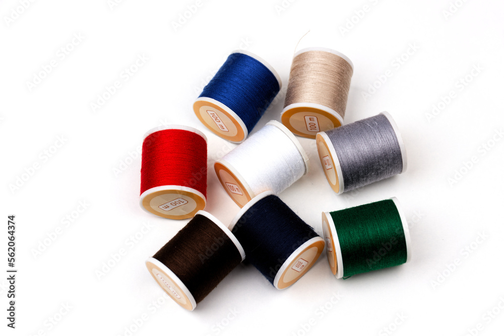 group of sewing spools isolated on white background with real shadows, different colors group of sewing spools isolated on white background with real shadows, different colors
