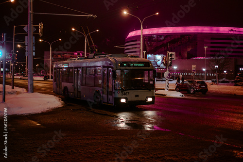 A bus is coming in the night city in winter