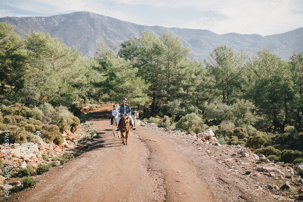 Obraz premium Group of people walking on horseback through picturesque places.