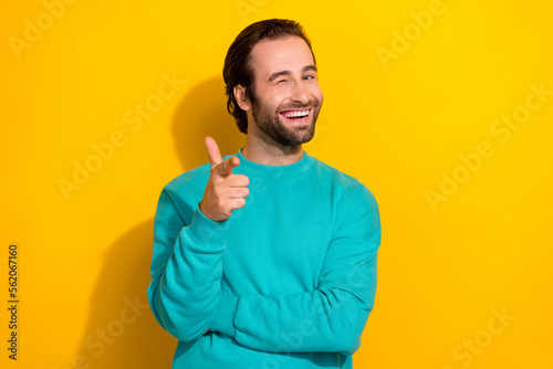 Photo of blinking eye young positive celebrity brunet hair guy finger directing you cool atmosphere invite party isolated on yellow color background