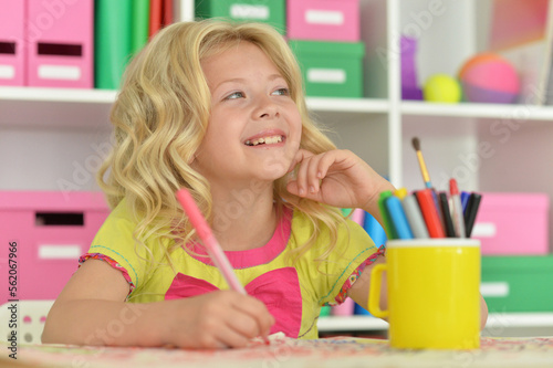 girl drawing picture at desk at home