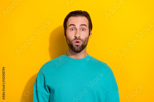 Portrait of funny young excited brunet hair guy pouted lips surprised big discotheque party invite free alcohol isolated on yellow color background