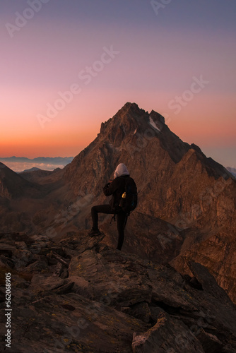 Obraz na płótnie A hiker taking photos of an amazing high altitude sunrise from a mountain top as clouds enshroud the valley below. Mountain tourism concept. Italian Alps, Monviso (2841 m) w salonie