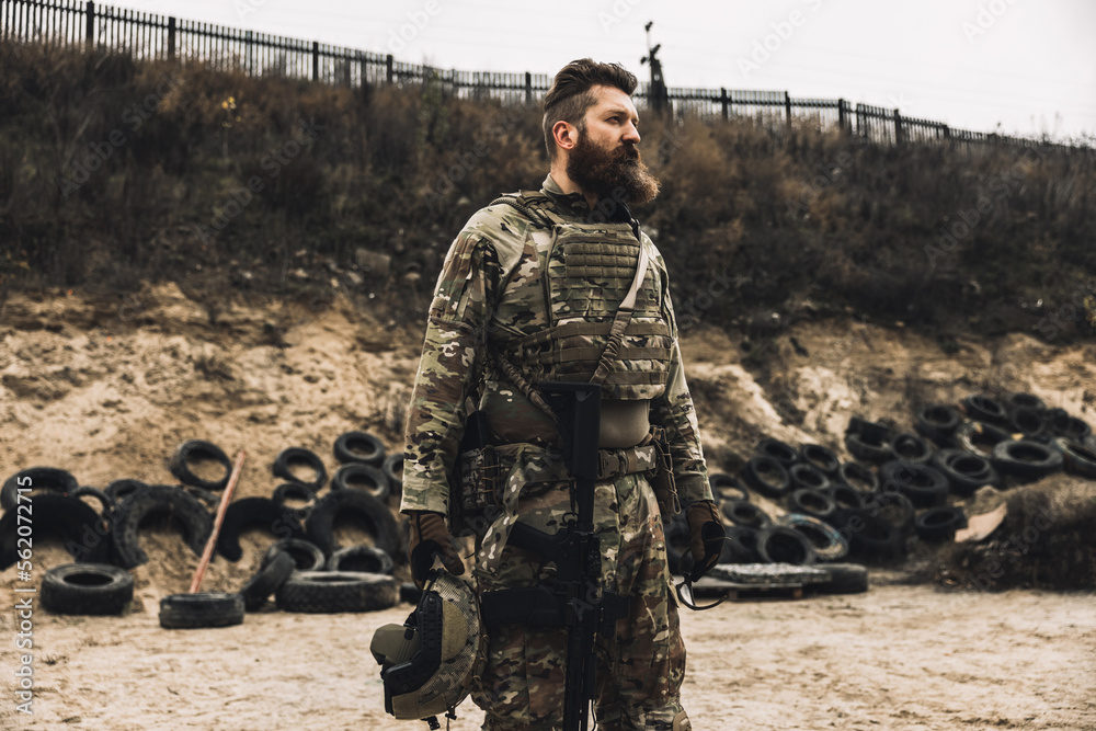 Naklejka premium Dark-haired bearded man in military uniform looking determined