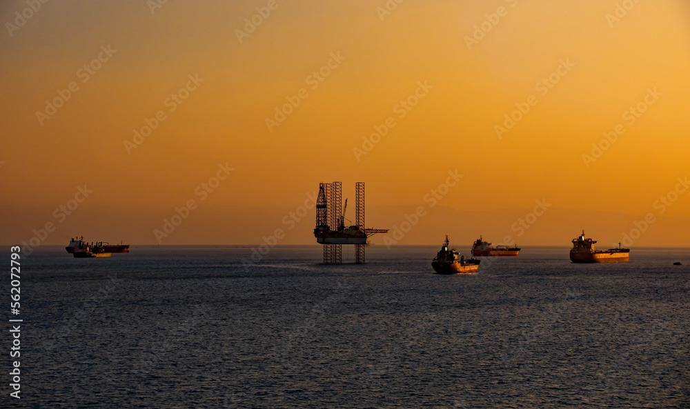 Fantastic sunset over the ocean. silhouettes of port cranes

