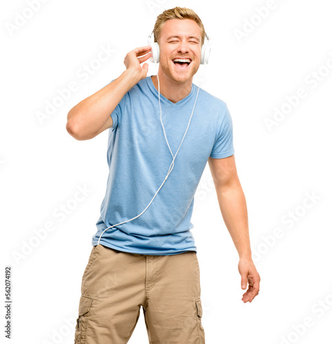 A handsome young man standing alone in the studio and listening to music through headphones isolated on a PNG background.