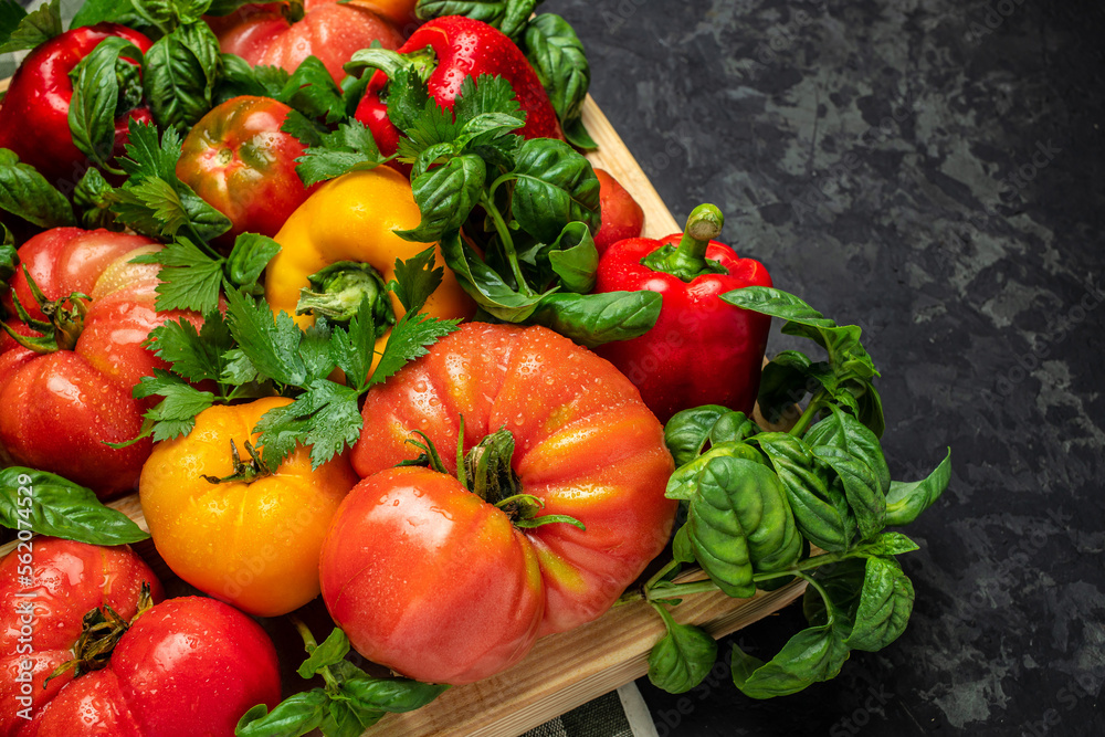 harvest of fresh vegetables on the table, pepper, tomato, basil, dark background. Flat lay. Top view harvest of fresh vegetables on the table, pepper, tomato, basil, dark background. Flat lay. Top view