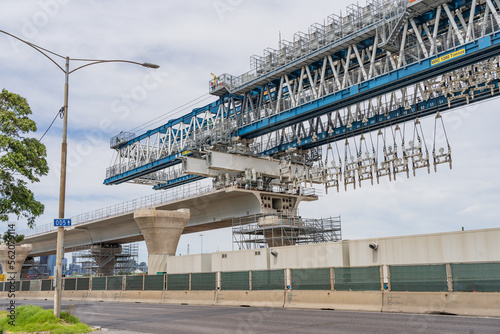a large suspension crane building an elevated freeway photo