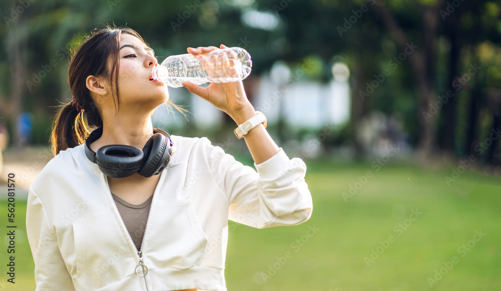 Portrait sport asian beauty body slim woman drinking water from a bottle while relax and feeling fresh on green natural background at summer green park.Healthy lifestyle concept Portrait sport asian beauty body slim woman drinking water from a bottle while relax and feeling fresh on green natural background at summer green park.Healthy lifestyle concept