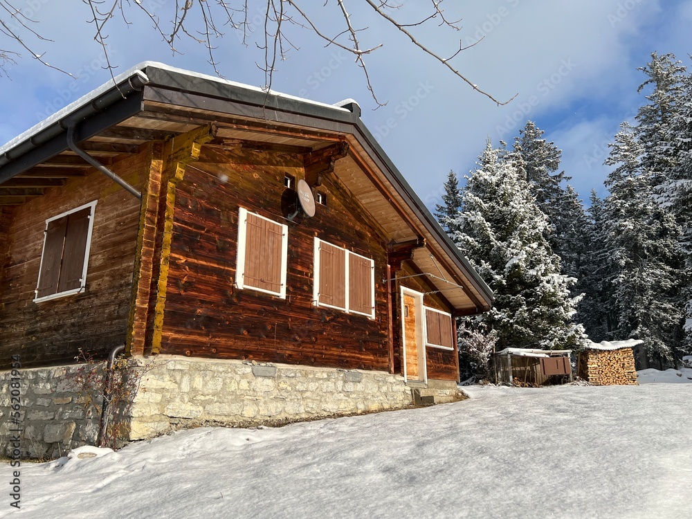 Old traditional swiss rural architecture and alpine livestock farms in the winter ambience over the Lake Walen or Lake Walenstadt (Walensee) and in the Swiss Alps, Amden - Switzerland / Schweiz