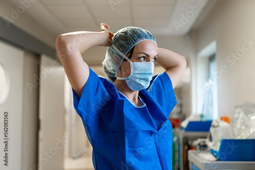 Nurse putting on her face mask in a hospital
