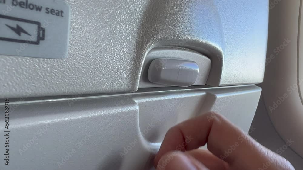 Closeup hand opening and closing plane tray table