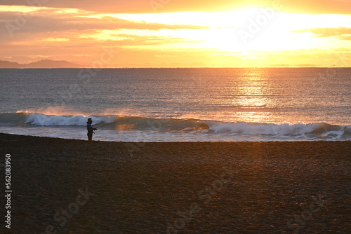 An angler aiming for flounder who is throwing and fishing on the beach at dawn. © tamu