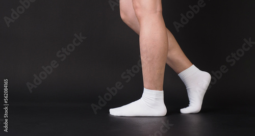 Asian Male legs wear white sock is isolated on black background