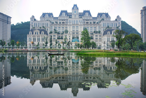 Building reflecting on calm lake against clear sky photo