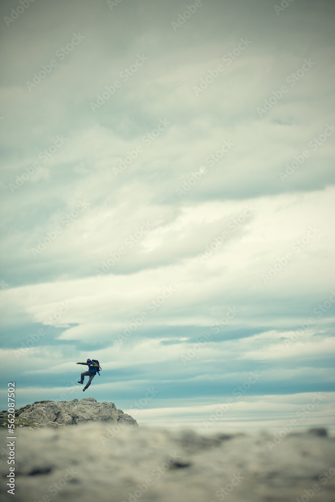 A man with backpack, kicking her heels in the air. Dolomite mountains, Italy A man with backpack, kicking her heels in the air. Dolomite mountains, Italy