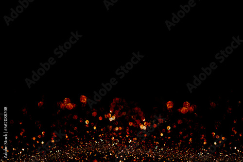 Gold red bokeh and shinhing particles on black backound for screen design. photo