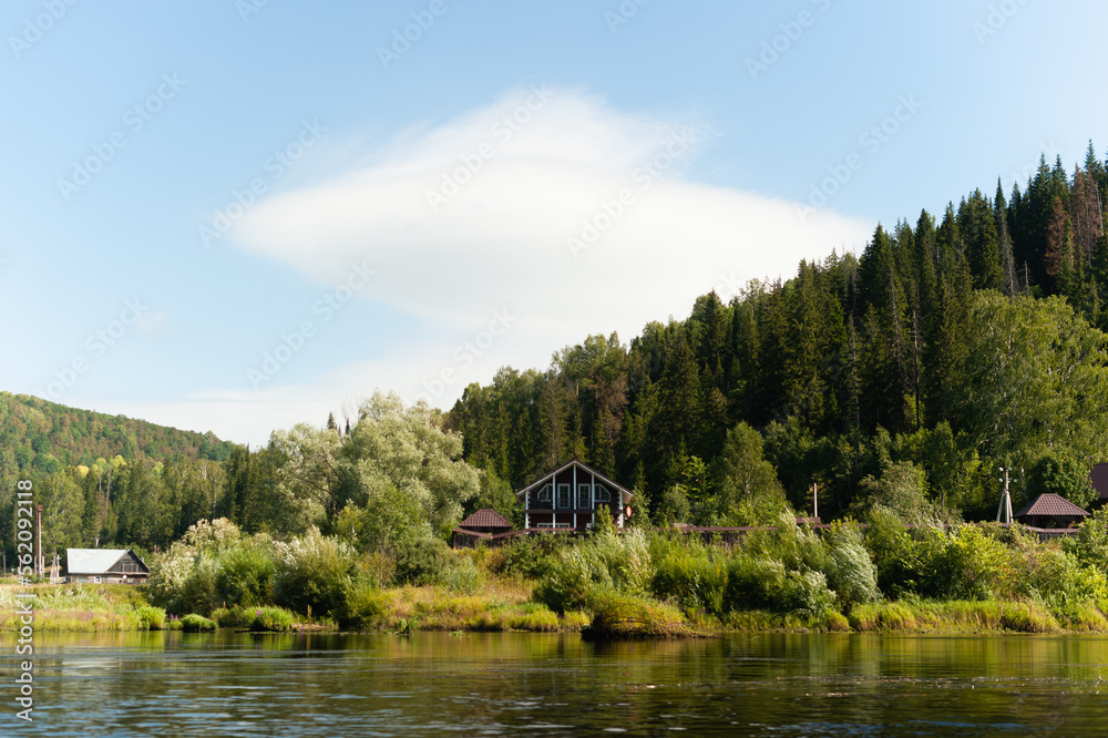 House by the water. A village in a dense forest on the banks of a river.