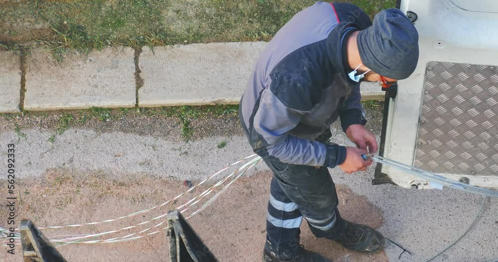 telecommunication technician proceeds with the cabling of fibre optic cables. In particular, individual fibre optic cables are pulled out of the protective sheathing telecommunication technician proceeds with the cabling of fibre optic cables. In particular, individual fibre optic cables are pulled out of the protective sheathing