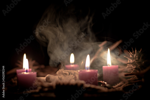 Voodoo doll, black candles, pentagram and old books on witch table. Occult, esoteric, divination and wicca concept. Mystic, voodoo and vintage background. photo