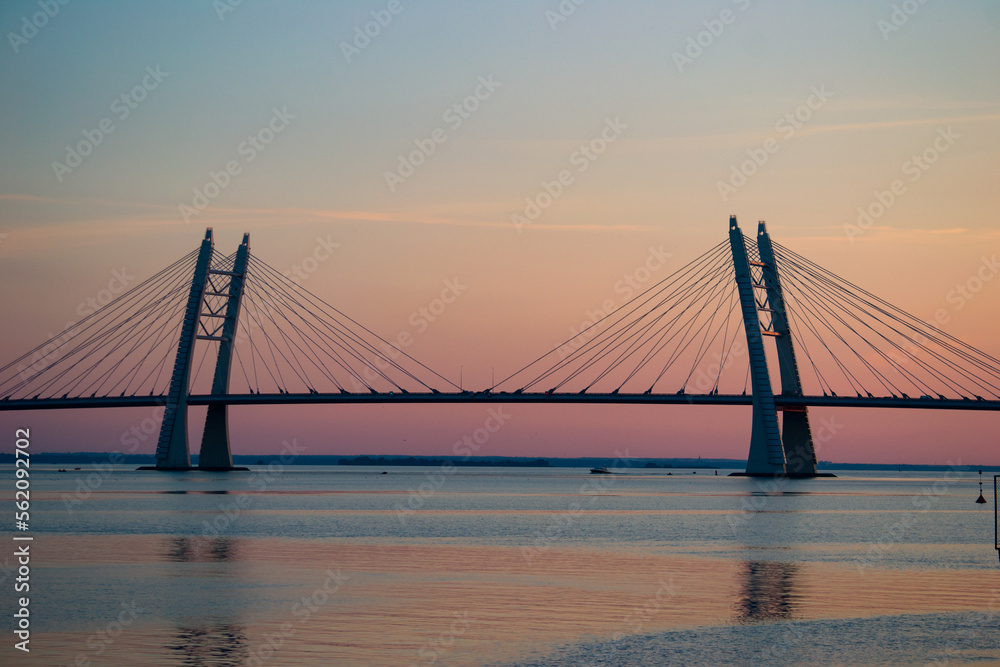 Beautiful cable-bridge on the sunset over the river. Perfect for posters, post cards, covers and wallpapers.