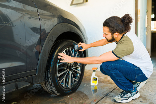 Mexican man cleaning the car tires © AntonioDiaz