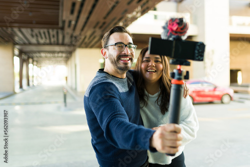 Excited woman and man hugging while filming a video vlog